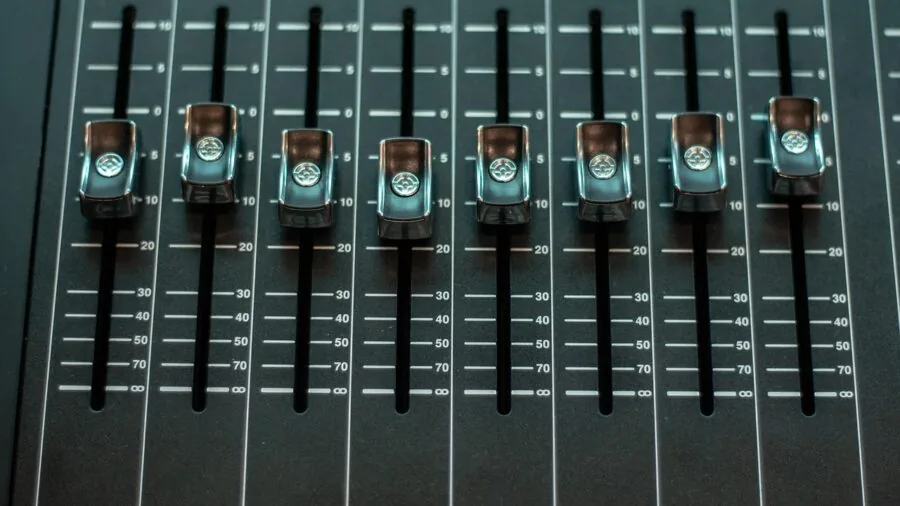 Person carefully adjusting audio equipment controls and settings during studio or home listening session