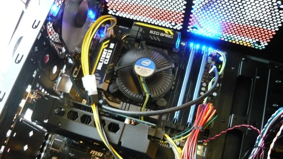 Person carefully installing CPU cooler mounting bracket on computer motherboard during PC build
