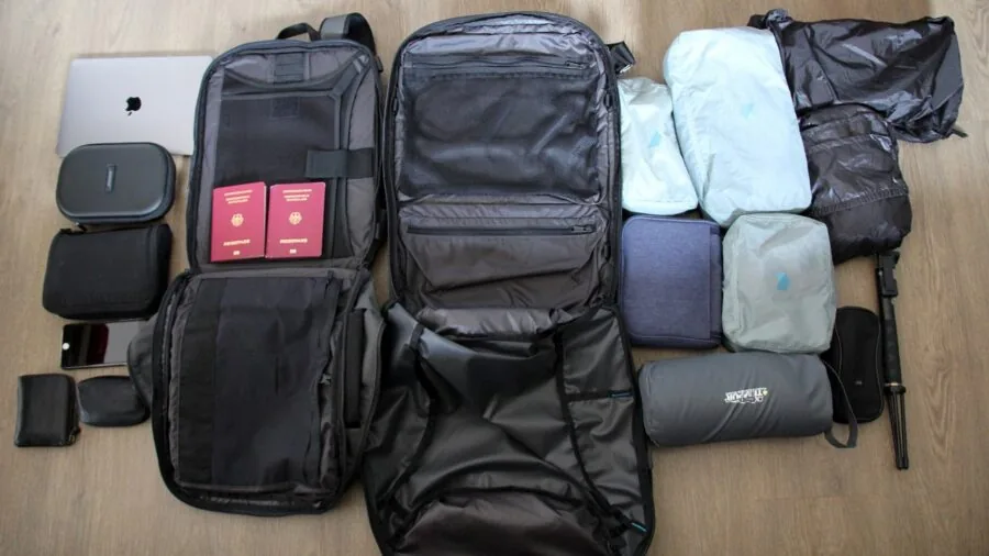 Person carefully packing wireless headphones into a travel carry-on bag during airport preparation