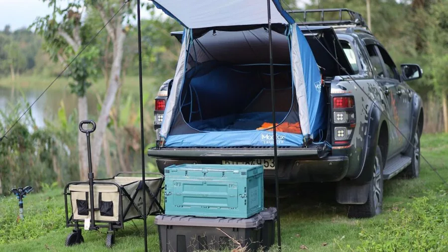 Person charging electronics inside a camping tent during outdoor adventure trip