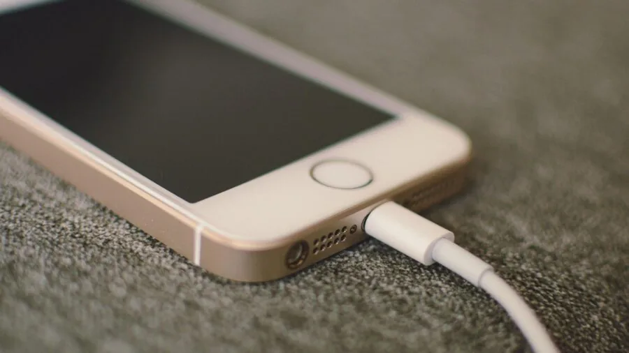 Person charging mobile device at airport gate during travel layover