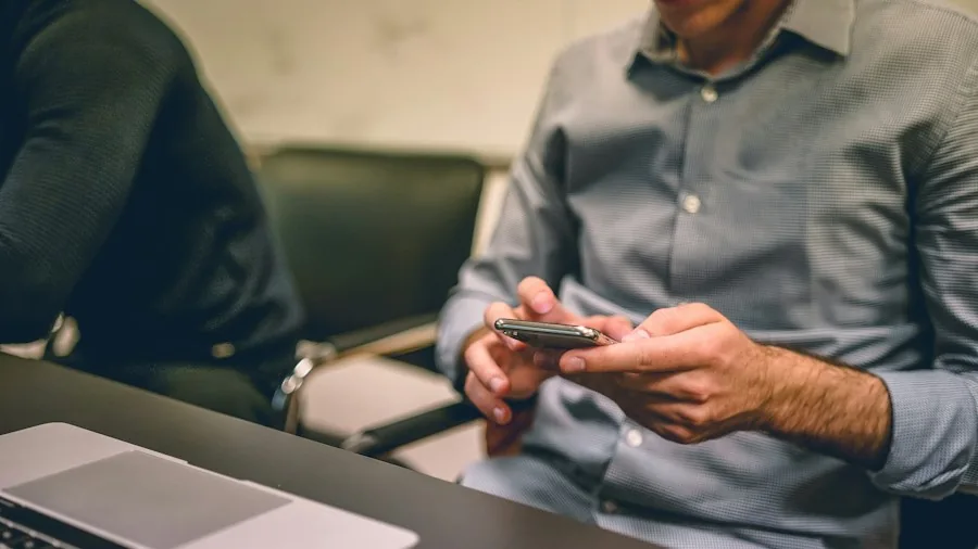 person charging phone on desk