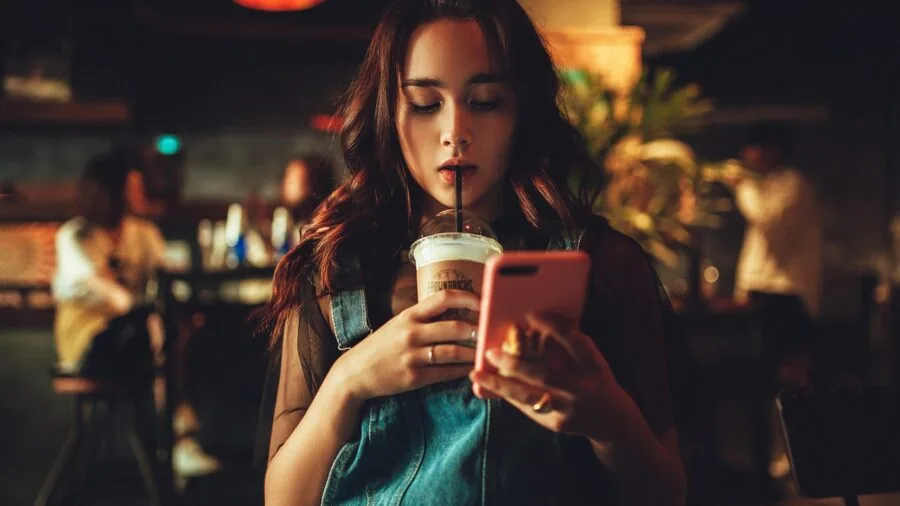 Person charging smartphone with portable power bank in everyday setting