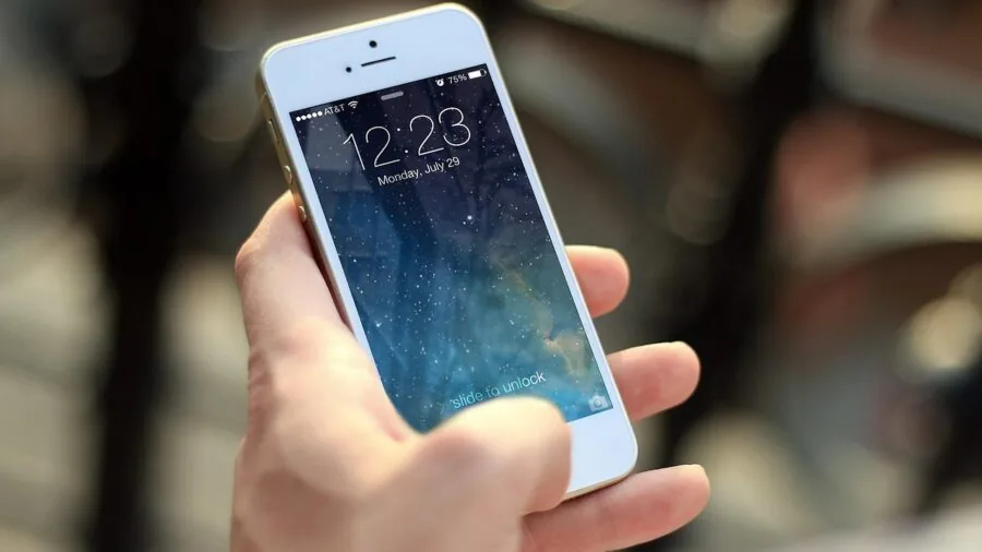 Person charging smartphone with power bank during travel, showing real-world mobile charging usage