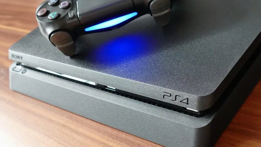 Person charging wireless game controller while relaxing at home gaming setup
