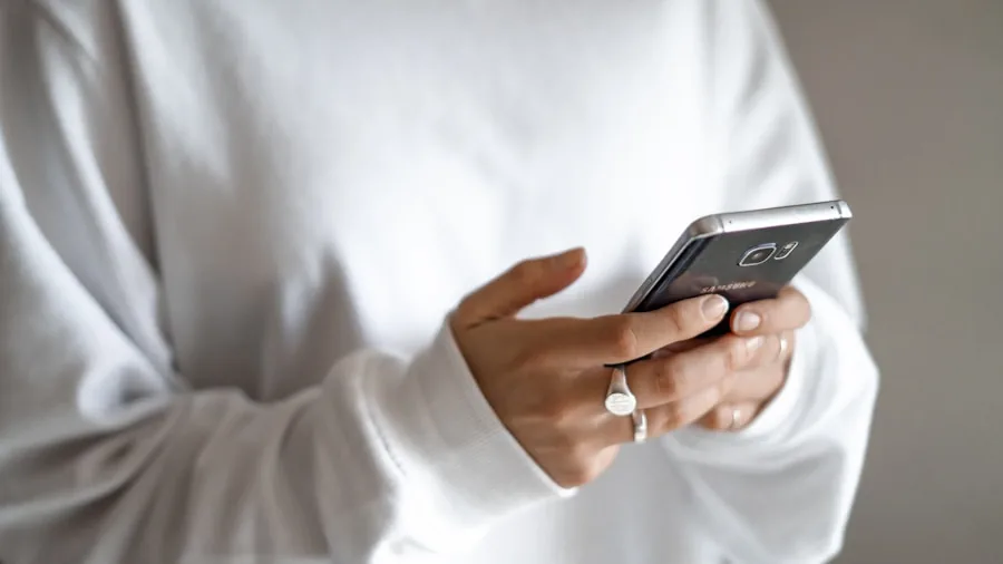 Person checking smartphone battery percentage during daily use, representing real-world battery endurance and mobile device usage