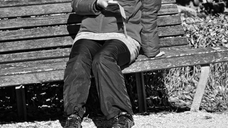Person checking smartphone battery percentage while holding device outdoors