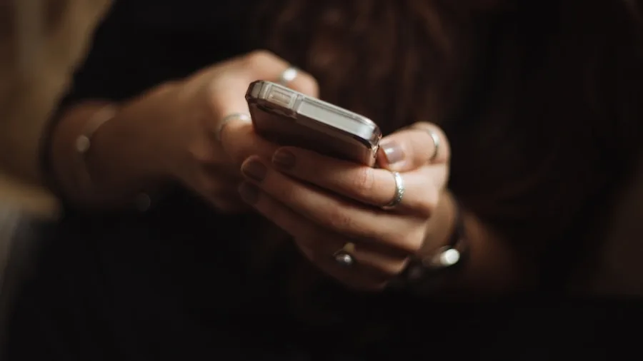 Person checking smartphone battery percentage while outdoors in natural daylight
