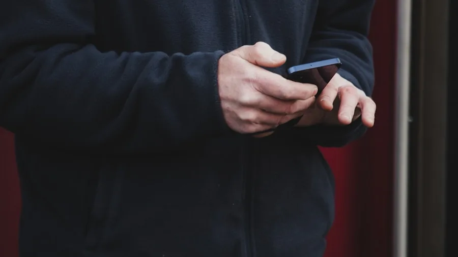 Person checking smartphone outdoors with natural lighting, representing mobile connectivity and battery usage
