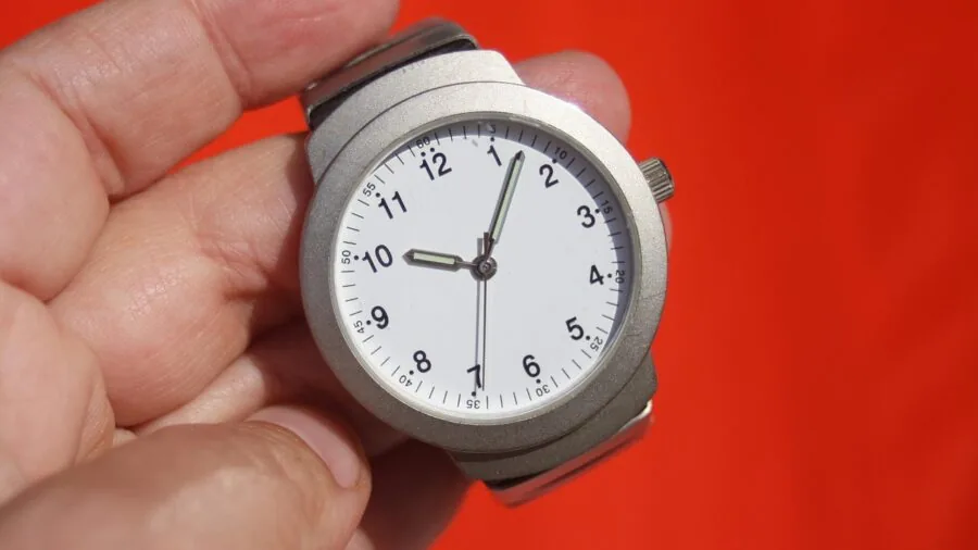 Person checking smartwatch screen in bright sunlight outdoors for visibility testing