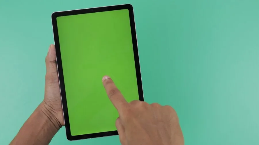 Person closely inspecting a tablet screen display in natural lighting to evaluate screen quality and clarity