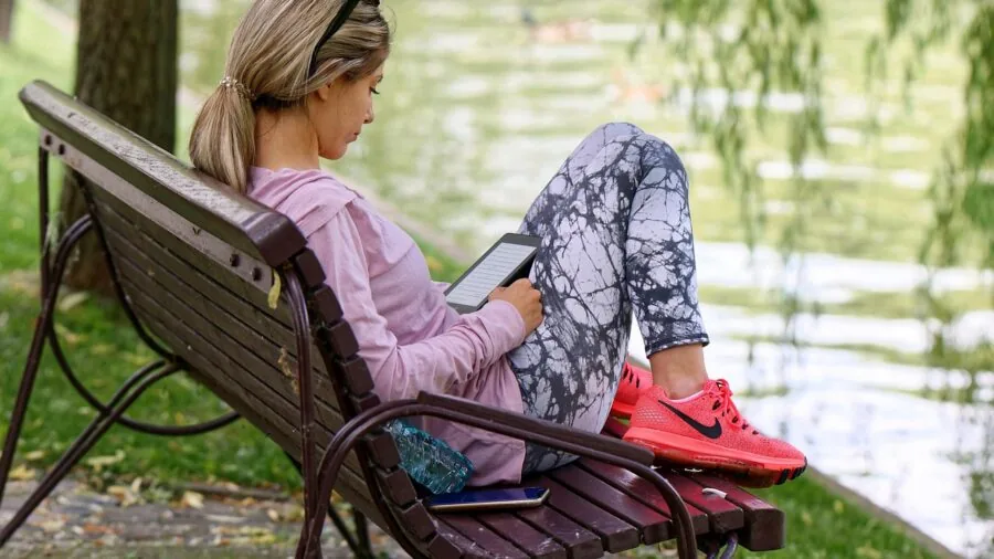 Person comfortably holding a tablet while reading in a relaxed lifestyle setting