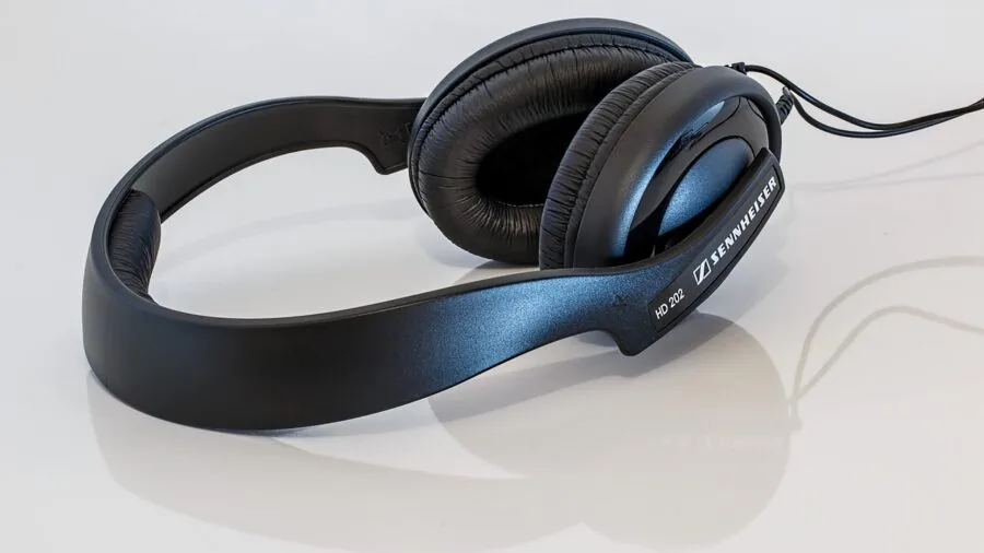 Person comfortably wearing lightweight headphones during extended listening session in natural setting