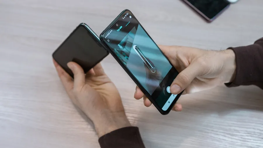 person comparing smartphone models side by side