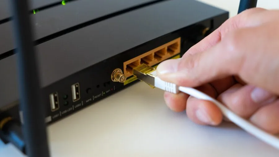 Person connecting audio cables to home entertainment system receiver in living room