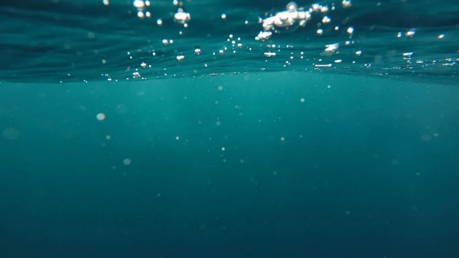 Person diving underwater in pool, testing water resistance and submersion depth