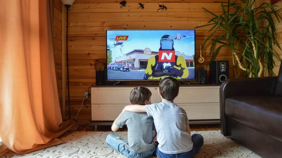 Person enjoying a movie on a television in a modern living room setting