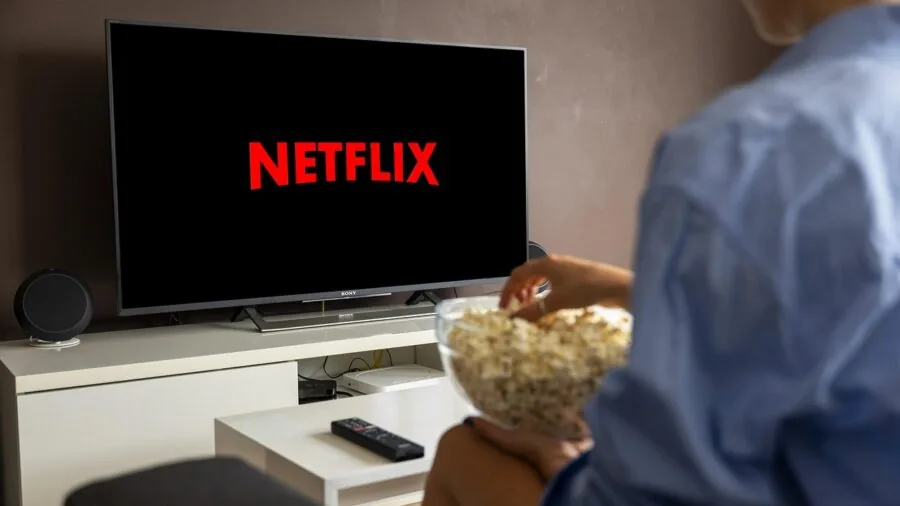 Person enjoying a movie on their home entertainment system in a comfortable living room setting