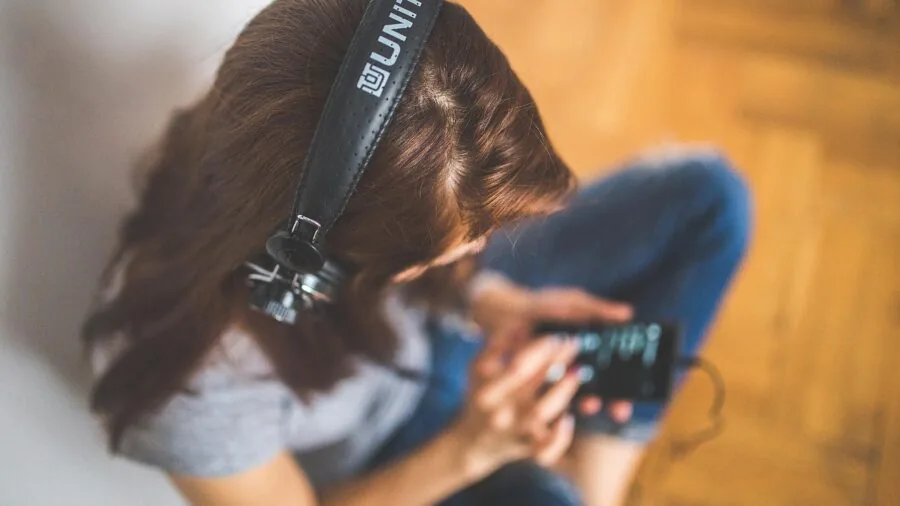 Person enjoying casual music listening in comfortable home setting with relaxed posture