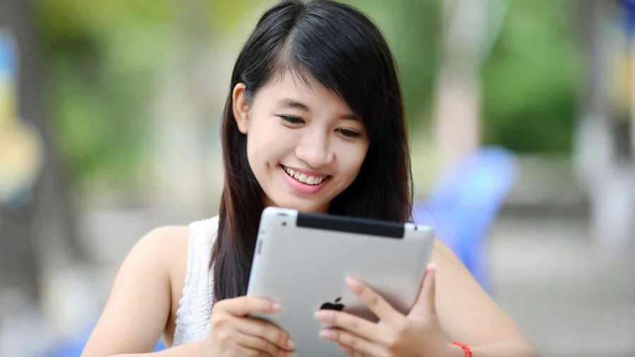 Person enjoying handheld gaming console outdoors during daytime with natural lighting
