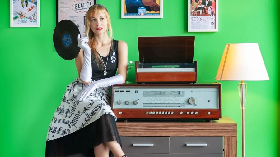 Person enjoying music from vinyl records in a cozy home listening space with warm lighting