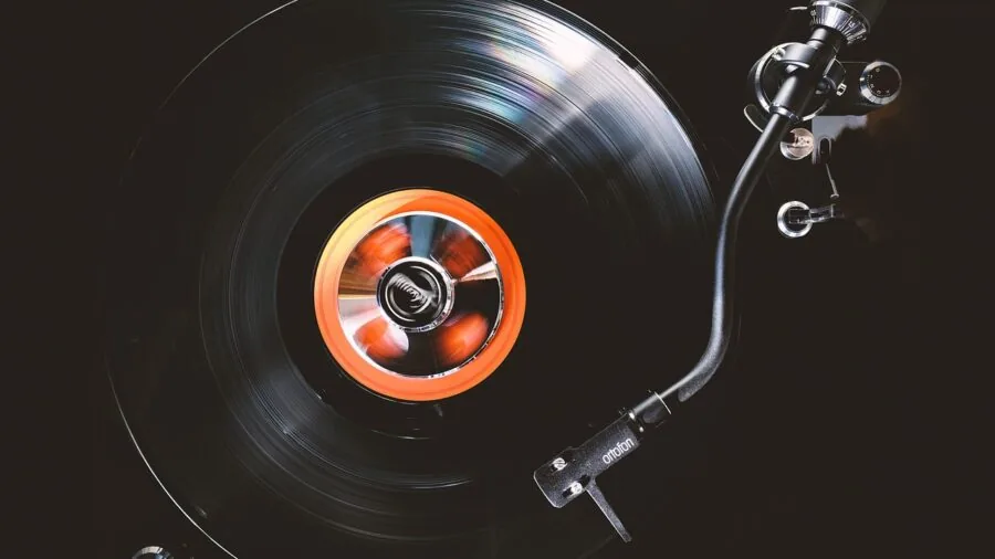 Person enjoying music in cozy room with vinyl records and warm lighting