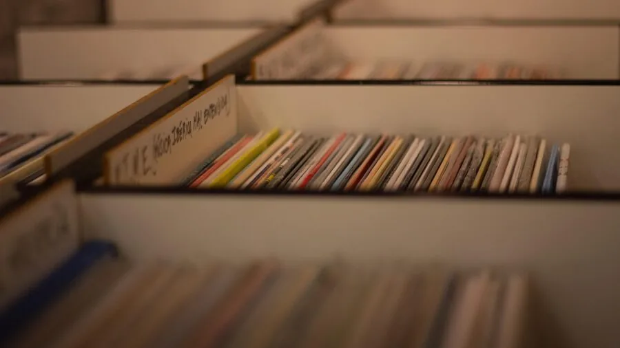 Person enjoying music on vinyl records in a cozy home setting with turntable
