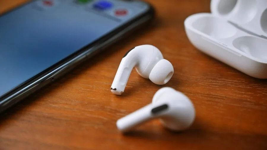 Person enjoying music outdoors with wireless earbuds, demonstrating modern audio connectivity lifestyle