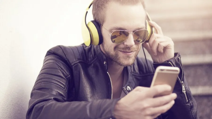 Person enjoying wireless audio while charging their smartphone during daily activities
