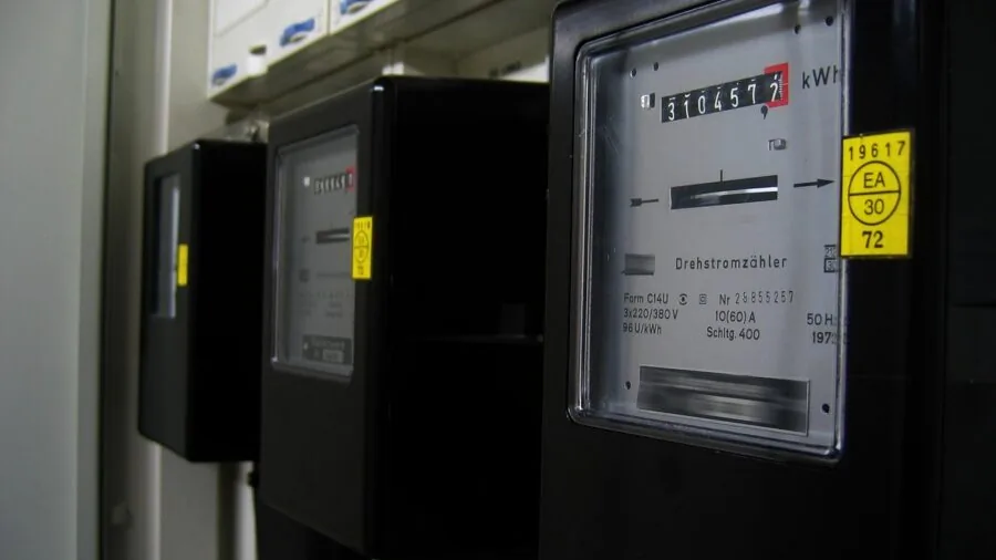 Person examining energy meter or power consumption display in home office setting