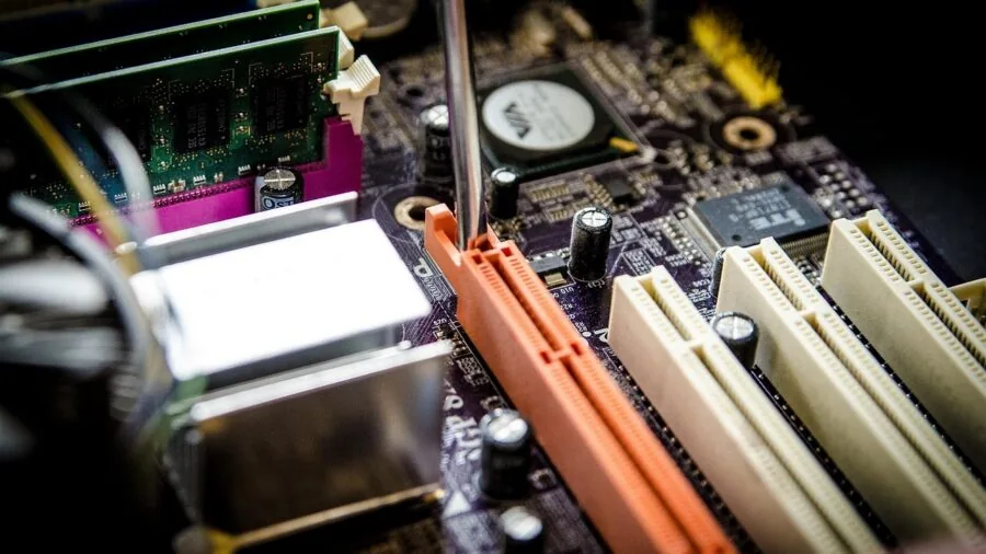 Person examining internal computer components and cables while checking compatibility requirements