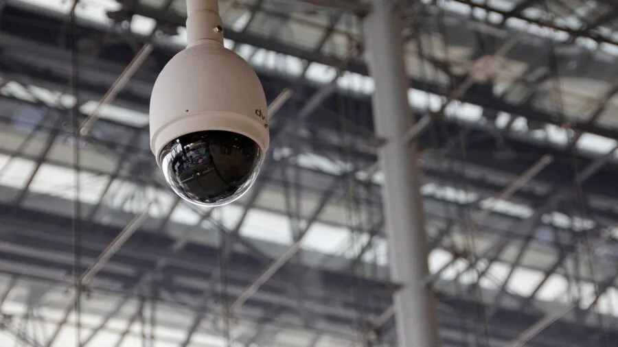 Person examining security camera footage on computer monitor indoors