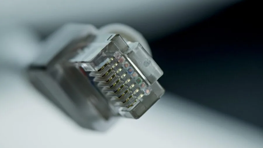 Person examining the back of a computer tower checking ports and cable connections for monitor setup