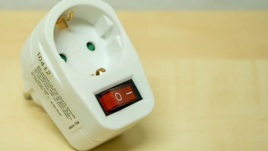 Person examining wall outlets in modern home during power management setup