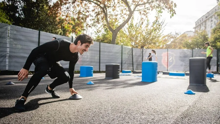 Person exercising outdoors with sweat and water droplets, demonstrating durability needs for sports headphones