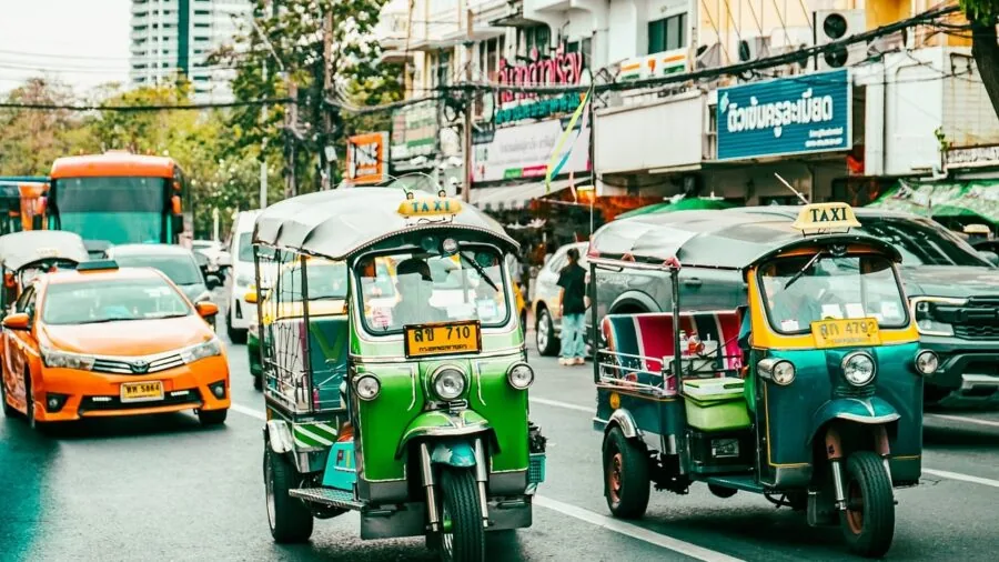 Person exploring a vibrant city street with camera, capturing travel moments during daytime exploration