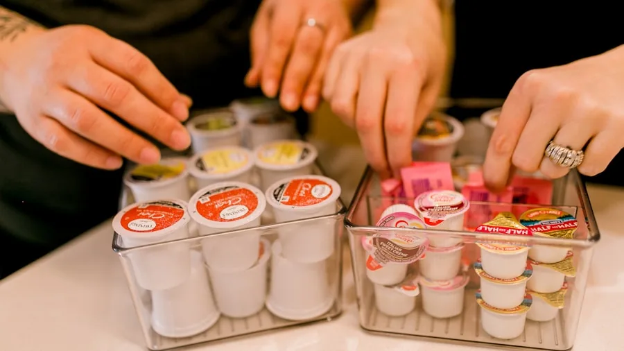 Person filling a large food storage container for pet supplies at home