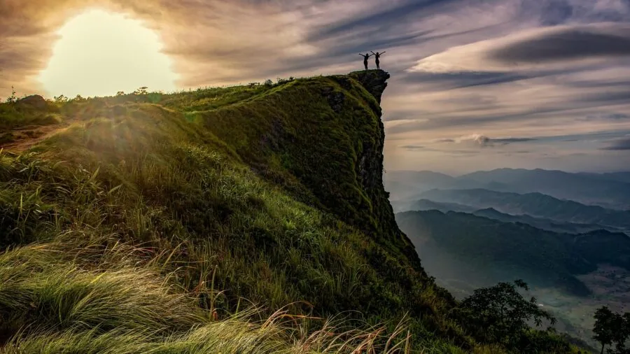 Person filming outdoors during golden hour with natural lighting in mountainous landscape