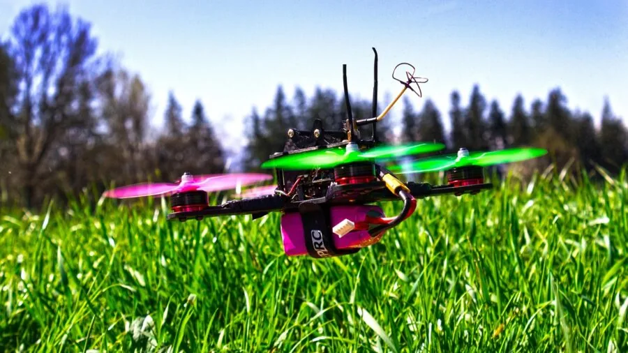 Person flying drone over scenic landscape during golden hour, demonstrating real-world flight conditions