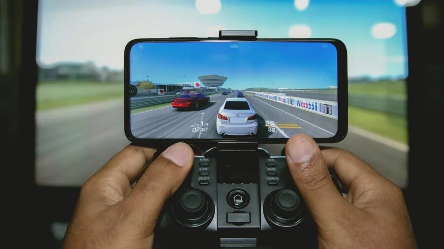Person gaming intensely with headphones on, focused on screen during action gameplay session