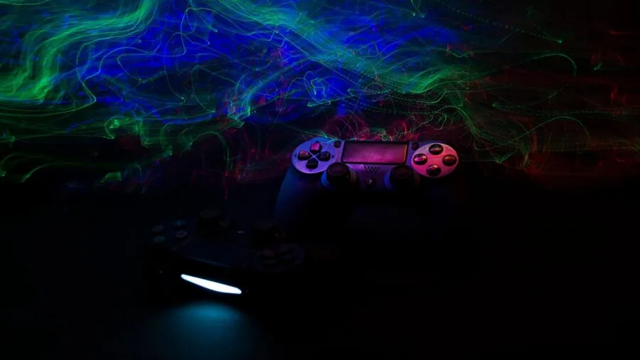 Person gaming on console controller in living room, focused on screen during gameplay session