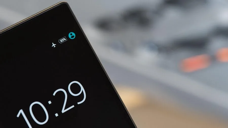 Person glancing at smartphone screen to check remaining battery percentage while working