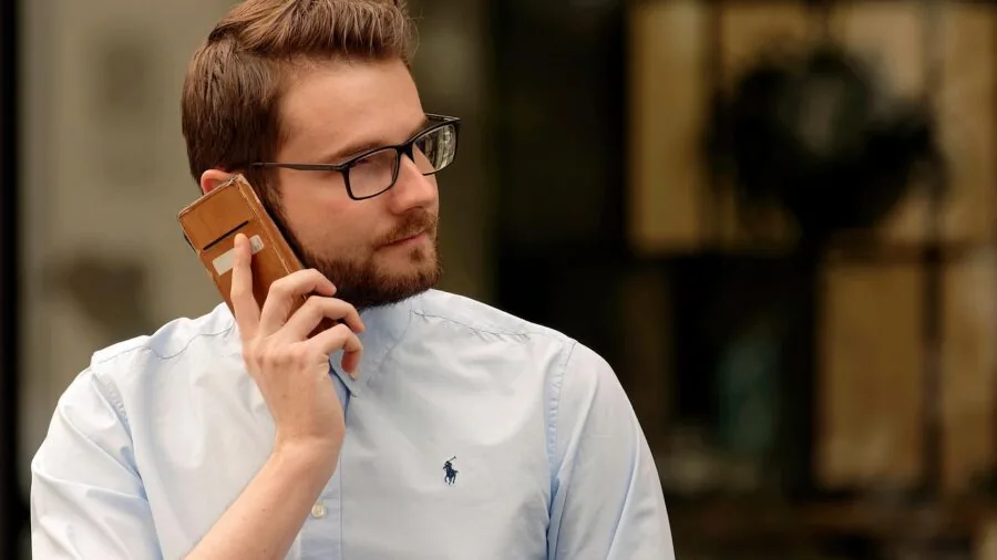 Person having a phone call outdoors in a natural setting, demonstrating wireless communication