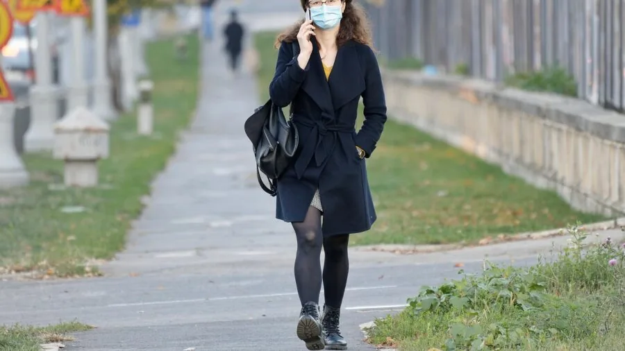 Person having a phone conversation while walking outside in natural daylight