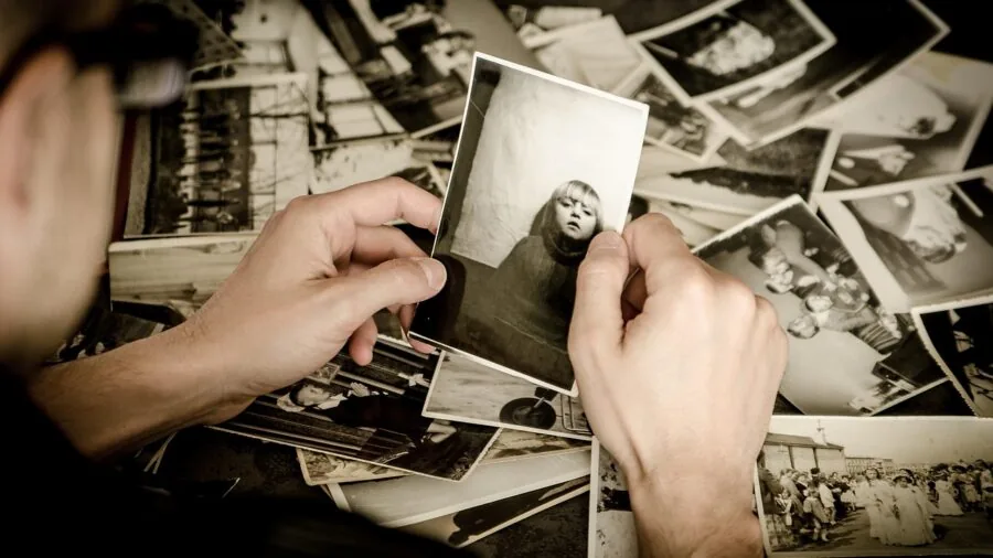 Person holding an instant camera outdoors, capturing memories in natural daylight
