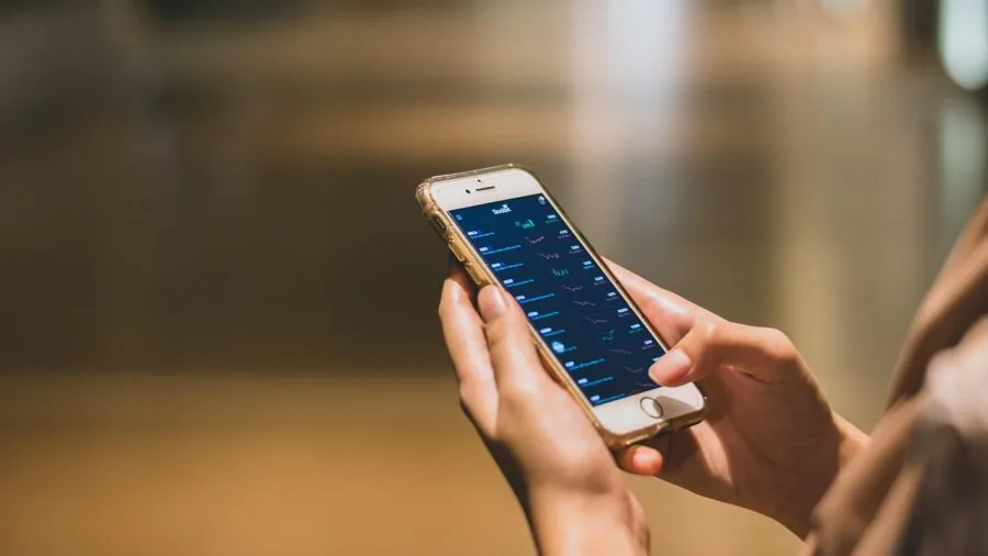 Person holding compact smartphone in hand, comparing size perspective