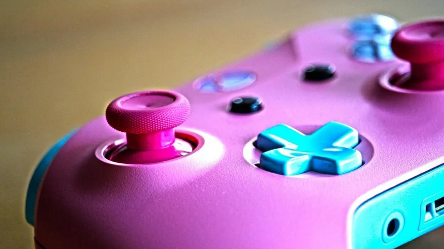 Person holding gaming controller with focused concentration while playing video game