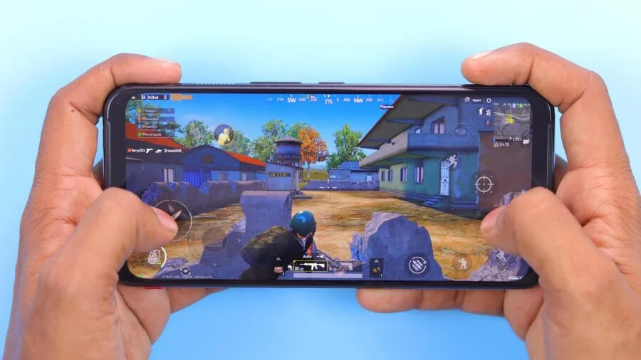 Person holding smartphone with game controller attachment during gameplay session