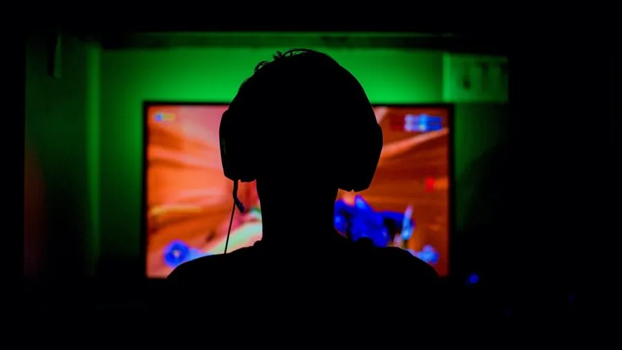 Person intensely focused while gaming on console, showcasing the immersive experience of modern gaming performance