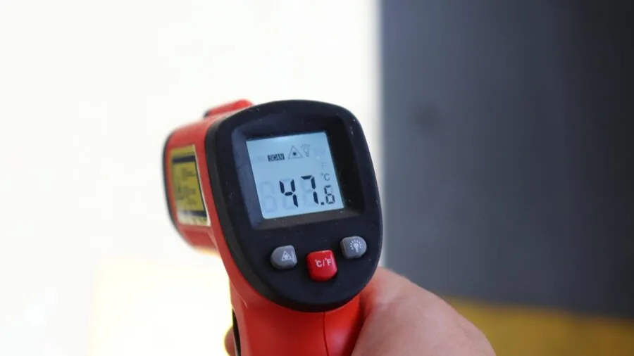Person interacting with wall-mounted digital temperature display in modern home interior